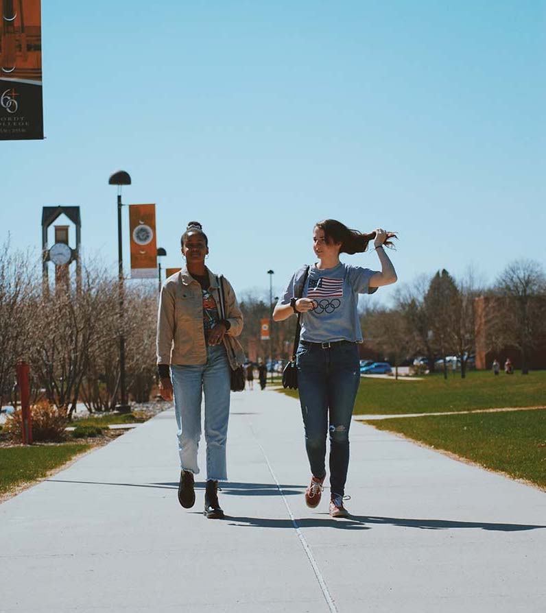 Two female students walking outside the student union.